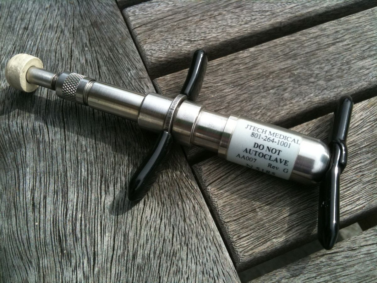 Hand-held Activator adjusting instrument on a wooden table